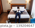Business traveler lying on hotel bed relaxing after successful trip and long journey 139204647