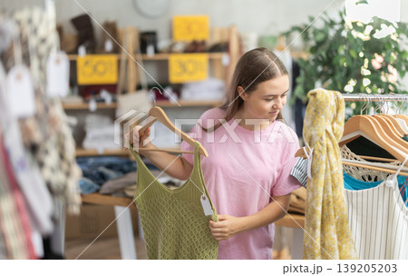 Teenage girl choosing top in clothing store 139205203