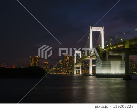 水面に白い光が反射するライトアップされたレインボーブリッジと街の風景 (東京都、港区、お台場) 水面に白い光が反射するライトアップされたレインボーブリッジと街の風景 (東京都、港区、お台場) 139205228