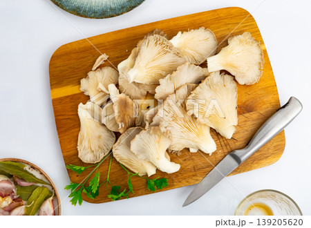 Preparing to cook soup or other dishes from fresh oyster mushrooms in kitchen 139205620