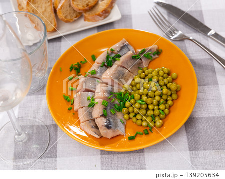Appetizing saltes slices herring fillet with canned green peas served on plate Appetizing saltes slices herring fillet with canned green peas served on plate 139205634