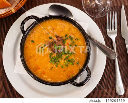 There is traditional Spanish dish on table - Fabada Asturian decorated with chopped green onions 139205759