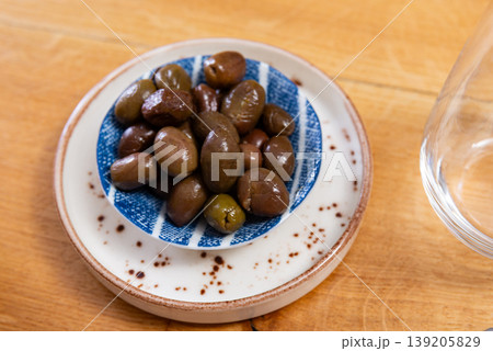 Green olives with pits served in bowl Green olives with pits served in bowl 139205829