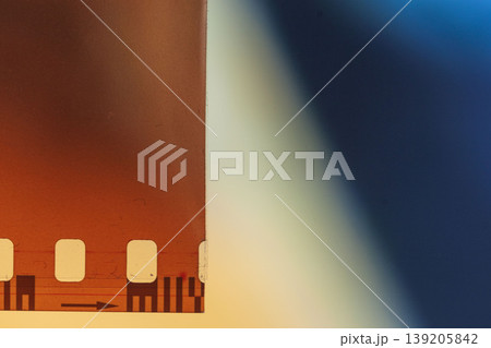 Closeup film negative strip edge, perforation marks, blur blue orange gradient, film detail, light leak, scan artifact texture in macro composition. Natural background, copy space for design 139205842