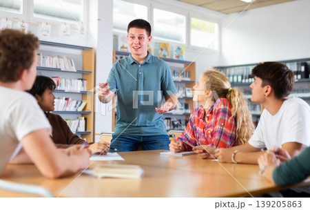 Group of schoolchildren in the school library, discussing something Group of schoolchildren in the school library, discussing something 139205863