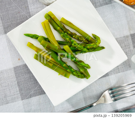 Fresh green asparagus with sunflower oil on white plate Fresh green asparagus with sunflower oil on white plate 139205969