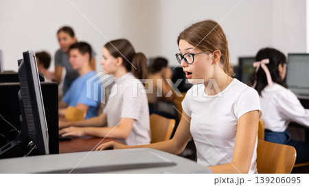 Amazed teenager girl using PC during computer science lesson Amazed teenager girl using PC during computer science lesson 139206095