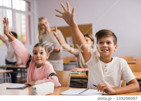 School pupils raise their hands up in classroom School pupils raise their hands up in classroom 139206097