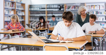 Teenager student sitting at desk in classroom at lesson in high school 139206116