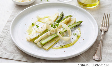 Gourmet appetizer with sliced vegetables and asparagus on a white plate the dish is presented on a clean white plate with a fork to the side fine dining olive oil food styling modern cuisine 139206378