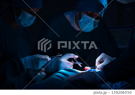 Group of concentrated surgical doctor team doing surgery patients in hospital operating theater. Professional medical team doing critical operations. Group of concentrated surgical doctor team doing surgery patients in hospital operating theater. Professional medical team doing critical operations. 139206550