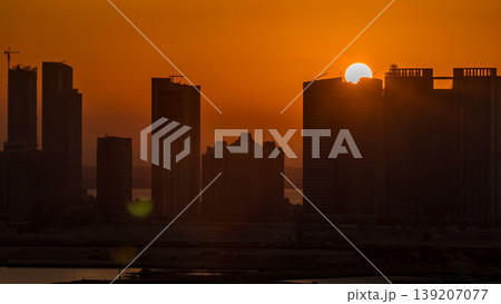 Buildings on Al Reem island in Abu Dhabi at sunset timelapse from above. 139207077