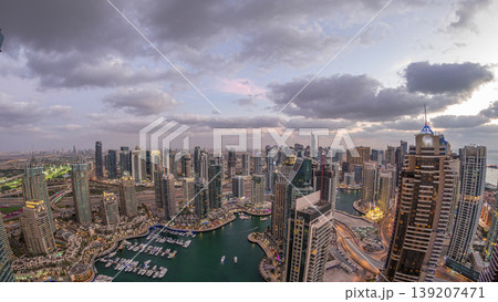 Dubai Marina skyscrapers and jumeirah lake towers view from the top aerial day to night timelapse in the United Arab Emirates. Dubai Marina skyscrapers and jumeirah lake towers view from the top aerial day to night timelapse in the United Arab Emirates. 139207471