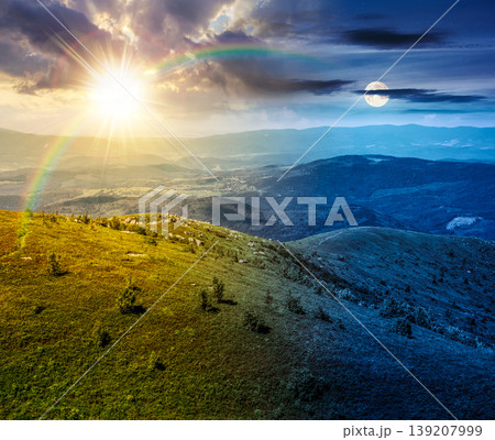 day meet night. mountain landscape with alpine meadow. sun and moon over carpathian mountain scenery on summer solstice. view in to the distant valley landscape. rolling hills and grassy meadow 139207999