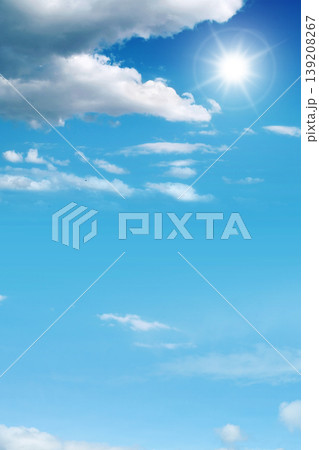 Vertical view of a brilliant sun shining brightly in a vivid blue sky with scattered fluffy white clouds, creating a peaceful and clear summer atmosphere Vertical view of a brilliant sun shining brightly in a vivid blue sky with scattered fluffy white clouds, creating a peaceful and clear summer atmosphere 139208267
