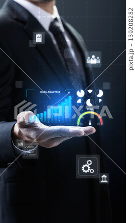 A businessman in a dark suit presents a futuristic virtual interface displaying data analysis, growing bar charts, risk indicators, and financial icons against a dark background A businessman in a dark suit presents a futuristic virtual interface displaying data analysis, growing bar charts, risk indicators, and financial icons against a dark background 139208282