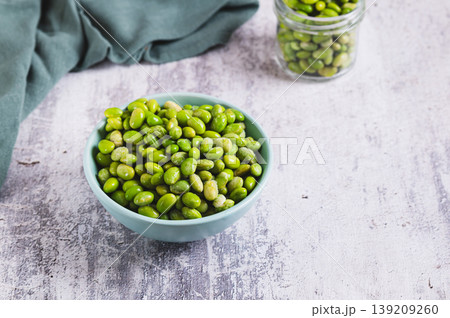Frozen edamame soybeans on a plate and in a jar on a table Frozen edamame soybeans on a plate and in a jar on a table 139209260