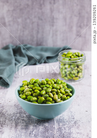 Frozen green peeled edamame beans in a bowl on a table vertical view Frozen green peeled edamame beans in a bowl on a table vertical view 139209261