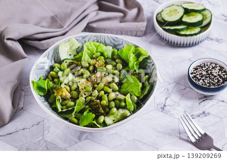 Delicious salad with edamame beans and vegetables in a bowl on the table Delicious salad with edamame beans and vegetables in a bowl on the table 139209269