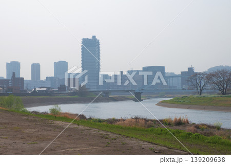 静かな川にかかる優雅なアーチ型の橋、背景には低層ビルが並ぶ静かな街並み 139209638