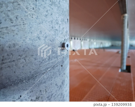 Concrete support column with fastener detail inside pig farm with installed plastic slatted flooring system and structural elements. Livestock farming, construction, agriculture 139209938