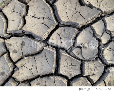 Dry cracked soil surface with large separated clay plates and deep fissures in arid outdoor environment. Drought, climate change, environment, water shortage, land degradation Dry cracked soil surface with large separated clay plates and deep fissures in arid outdoor environment. Drought, climate change, environment, water shortage, land degradation 139209978