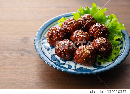 木製テーブルと和皿に盛られた肉団子(甘酢あん・ミートボール・コピースペース) 木製テーブルと和皿に盛られた肉団子(甘酢あん・ミートボール・コピースペース) 139210371