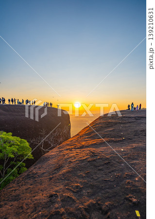 Tiny Figures on a Colossal Cliff at Sunrise 139210631