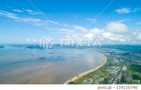 Vostochny Port and Nakhodka Bay aerial view with numerous cargo ships under a bright blue sky Vostochny Port and Nakhodka Bay aerial view with numerous cargo ships under a bright blue sky 139210740