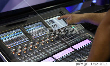 Mixing operation. Professional audio or sound engineers operating digital mixing consoles in studio or live mix perform. Sound control music production broadcasting mix and live event audio technology Mixing operation. Professional audio or sound engineers operating digital mixing consoles in studio or live mix perform. Sound control music production broadcasting mix and live event audio technology 139210987