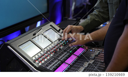 Mixing operation. Professional audio or sound engineers operating digital mixing consoles in studio or live mix perform. Sound control music production broadcasting mix and live event audio technology 139210989