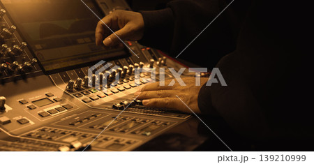 Mixing operation. Professional audio or sound engineers operating digital mixing consoles in studio or live mix perform. Sound control music production broadcasting mix and live event audio technology Mixing operation. Professional audio or sound engineers operating digital mixing consoles in studio or live mix perform. Sound control music production broadcasting mix and live event audio technology 139210999