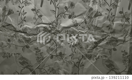 crumpled vintage botanical paper texture with flying birds and blooming flowers evoking nostalgic mood for wallpaper or editorial background crumpled vintage botanical paper texture with flying birds and blooming flowers evoking nostalgic mood for wallpaper or editorial background 139211110