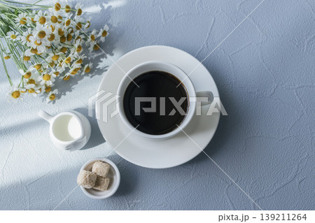 花とコーヒーの朝時間 青い背景に映える爽やかな俯瞰テーブルフォト 139211264