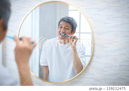 鏡を見ながら歯磨きをする60代の男性 鏡を見ながら歯磨きをする60代の男性 139212475