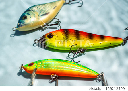 Flat lay of fishing equipment on blue background with water shadows. Close up of tackles and baits 139212509