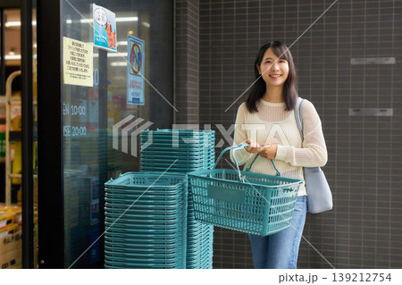 スーパーマーケットでカゴを持って買い物をする若い女性 139212754