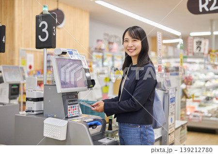 セルフレジでスマートフォン決済をする若い女性 セルフレジでスマートフォン決済をする若い女性 139212780