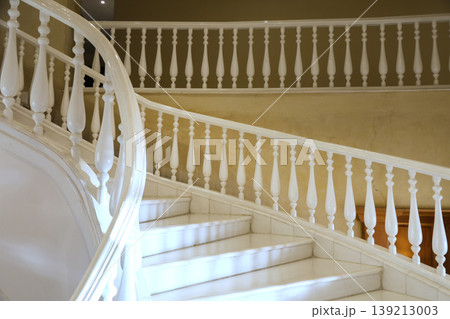 Elegant White Winding Staircase with Marble Steps, Showcasing Timeless Design and Luxurious Aesthetics in a Bright and Airy Space 139213003