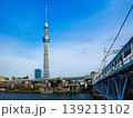 歩道が併設された鉄骨橋と桜並木が彩る水辺から見上げる東京スカイツリーの春の風景 (東京都、墨田区) 139213102