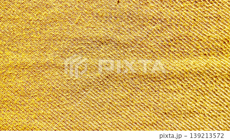 golden yellow denim fabric texture closeup revealing intricate diagonal twill weave and warm fibrous details 139213572