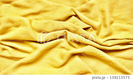 vibrant yellow terrycloth towel folds closeup textured fabric background abstract soft waves golden sunlight mood tactile surface detail 139213573