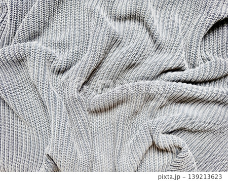 gray ribbed knit fabric soft texture close up elegant drapes folds cozy winter warmth tactile wool material abstract pattern gray ribbed knit fabric soft texture close up elegant drapes folds cozy winter warmth tactile wool material abstract pattern 139213623