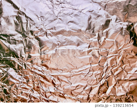 crumpled aluminum foil texture shining with metallic silver wrinkles and abstract warm toned folds crumpled aluminum foil texture shining with metallic silver wrinkles and abstract warm toned folds 139213654