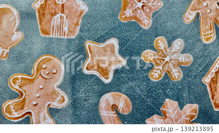gingerbread cookie assortment in whimsical holiday shapes scattered on textured teal fabric evoking cozy christmas cheer gingerbread cookie assortment in whimsical holiday shapes scattered on textured teal fabric evoking cozy christmas cheer 139213895