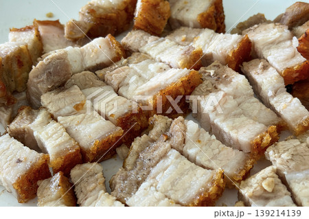 Crispy roasted pork belly pieces arranged closely representing savory food texture and traditional roasted meat cuisine. 139214139
