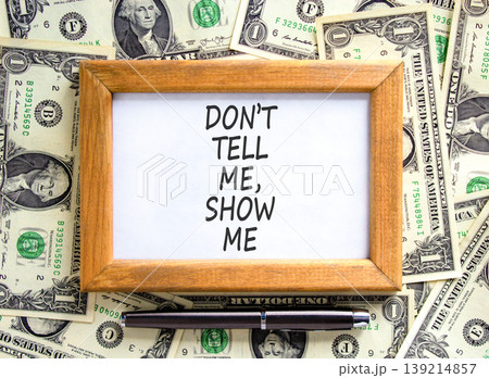 Tell or show symbol. Concept words Do not tell me, show me on beautiful wooden picture frame. Beautiful dollar bills background. Dollar bills. Business tell or show concept. Copy space. 139214857