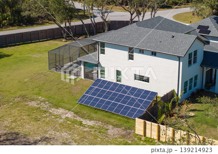 Solar photovoltaic panels mounted on backyard ground near autonomous home 139214923