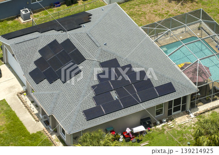 Solar panels on residential house rooftop. Photovoltaic sells for producing of clean electrical energy in suburban rural area. Concept of investment in autonomous home Solar panels on residential house rooftop. Photovoltaic sells for producing of clean electrical energy in suburban rural area. Concept of investment in autonomous home 139214925