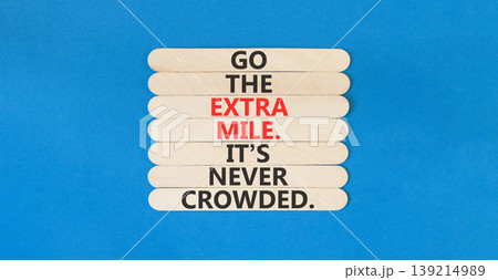 Go the extra mile symbol. Concept words Go the extra mile. It's never crowded on beautiful wooden sticks. Beautiful blue paper background. Business go the extra mile concept. Copy space. 139214989